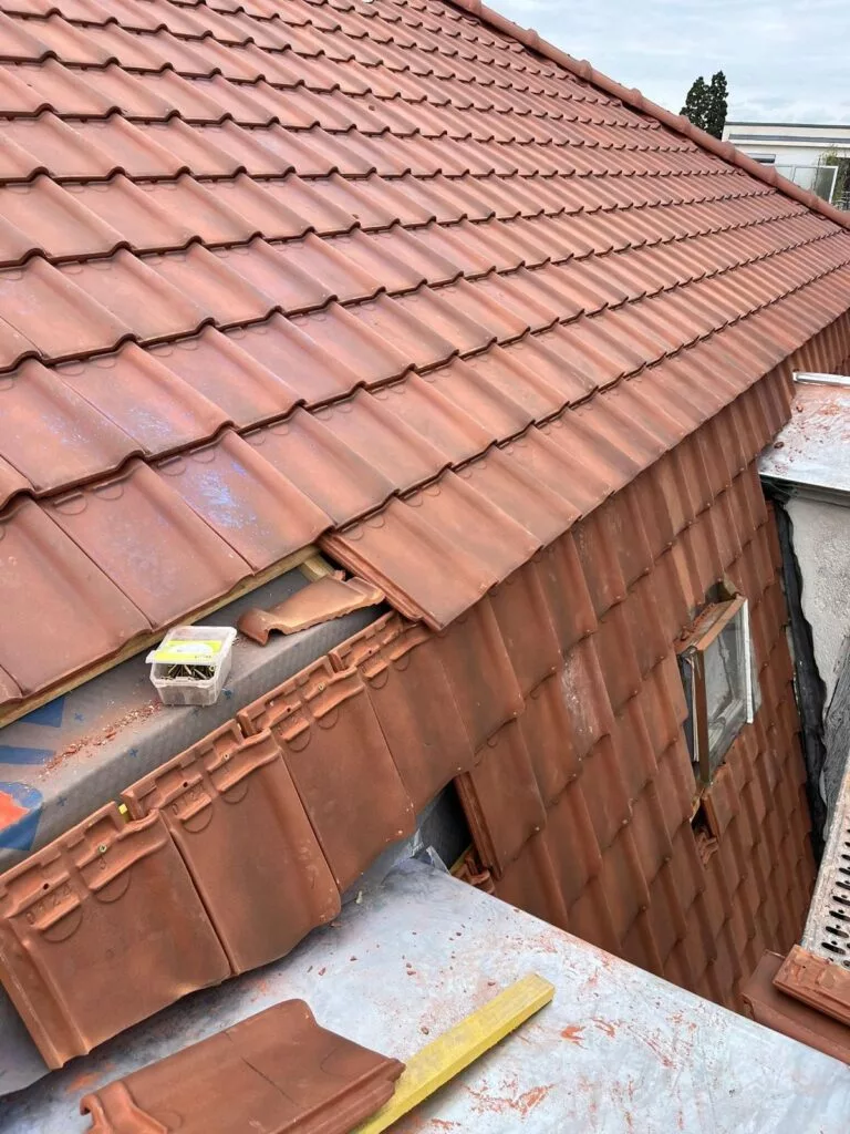 Pose de tuiles neuves sur une toiture de Lutry